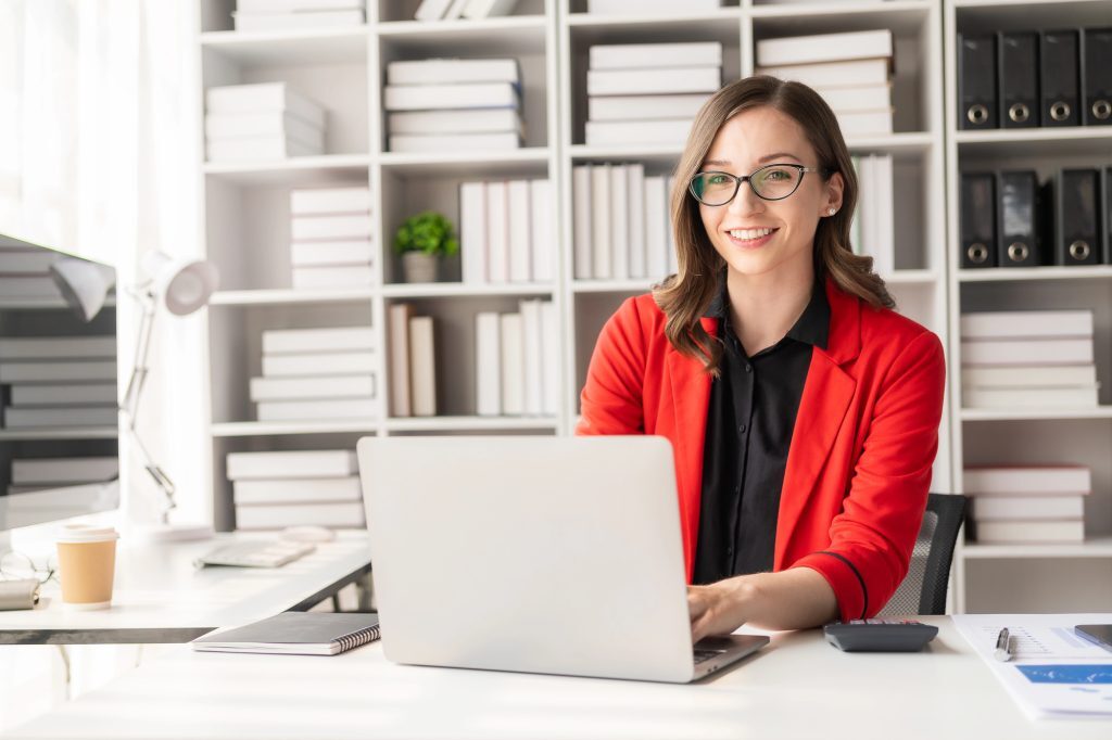 Smiling professional working on a laptop for New York No-Fault Collections